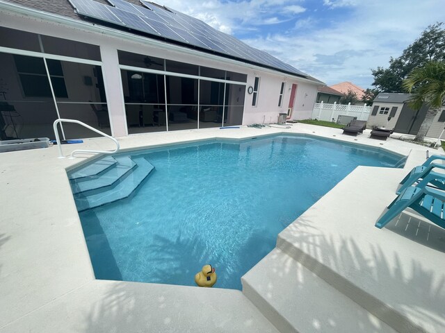 view of swimming pool with a patio area and a storage shed