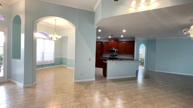 kitchen with crown molding, pendant lighting, electric range, a chandelier, and a breakfast bar area