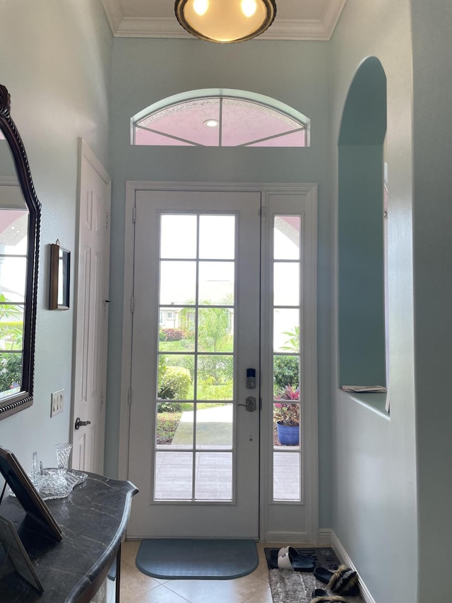 doorway to outside with tile patterned flooring and crown molding