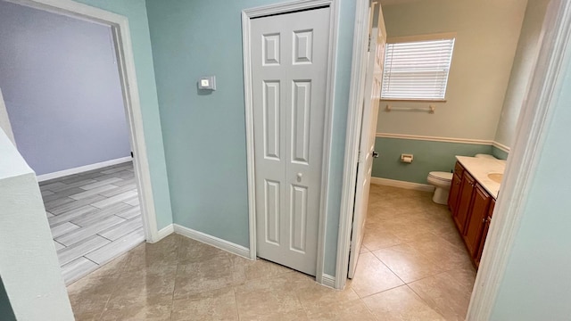 bathroom featuring tile patterned flooring, vanity, and toilet