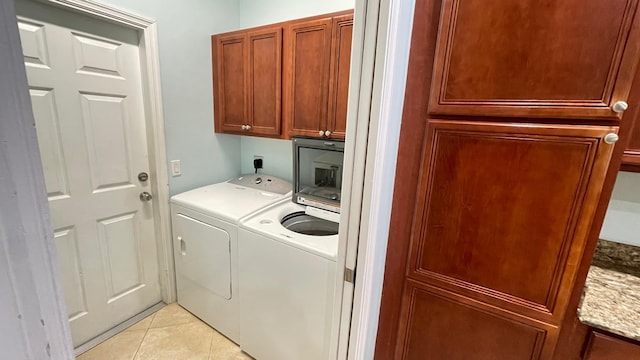 washroom featuring cabinets, independent washer and dryer, and light tile patterned floors