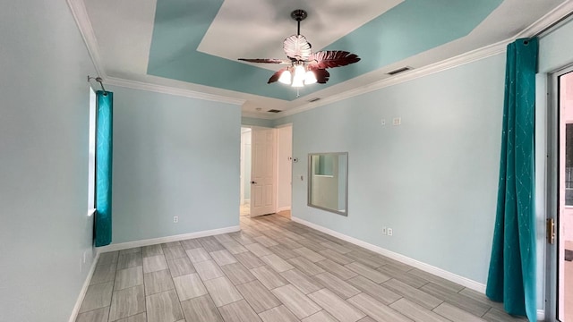 spare room with ceiling fan, a raised ceiling, and crown molding