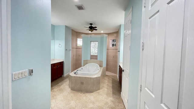 bathroom with ceiling fan, vanity, and plus walk in shower