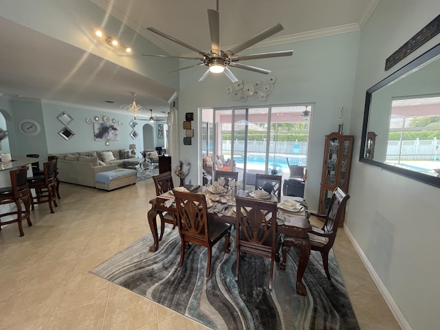 tiled dining area with ceiling fan, a healthy amount of sunlight, a high ceiling, and ornamental molding