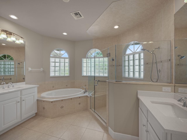 bathroom featuring plus walk in shower, tile patterned flooring, and vanity