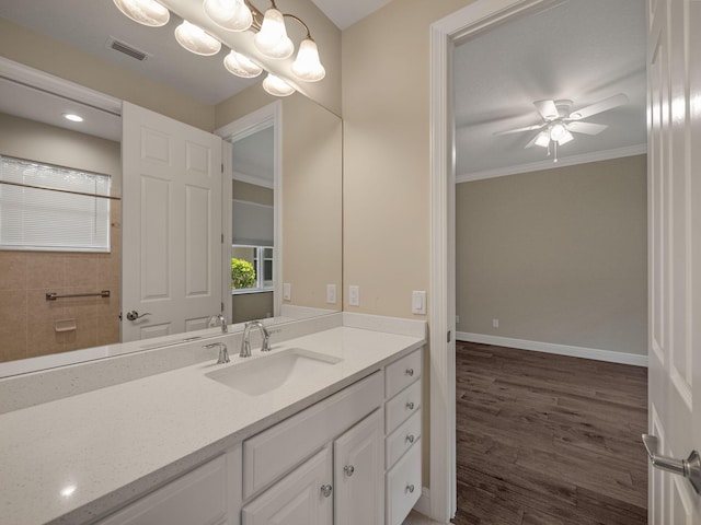 bathroom featuring ceiling fan with notable chandelier, vanity, crown molding, and wood-type flooring