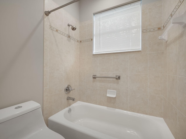 bathroom with tiled shower / bath and toilet