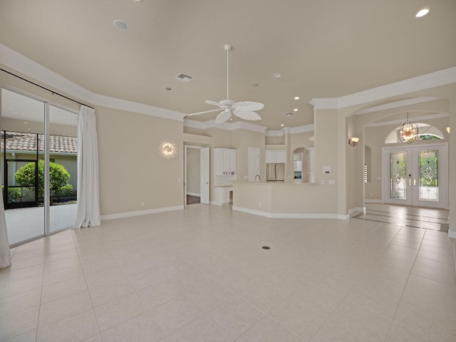 unfurnished living room with ceiling fan with notable chandelier, a healthy amount of sunlight, french doors, and ornamental molding