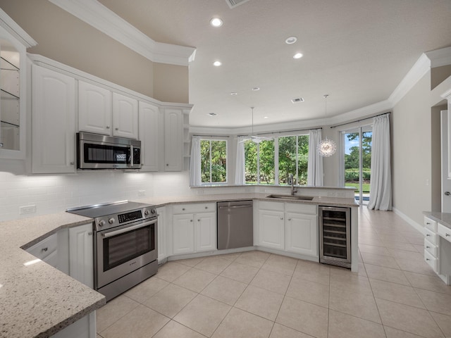 kitchen with appliances with stainless steel finishes, sink, white cabinets, and wine cooler