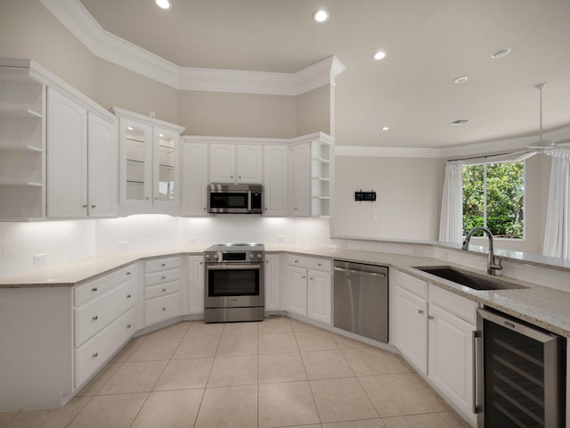 kitchen with white cabinetry, stainless steel appliances, beverage cooler, and sink