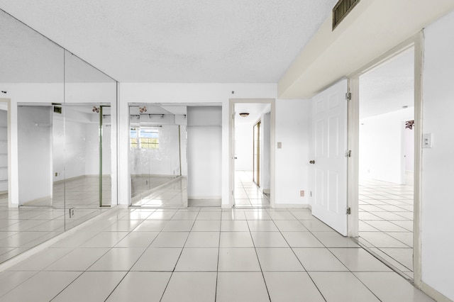 unfurnished bedroom featuring a textured ceiling and light tile patterned flooring