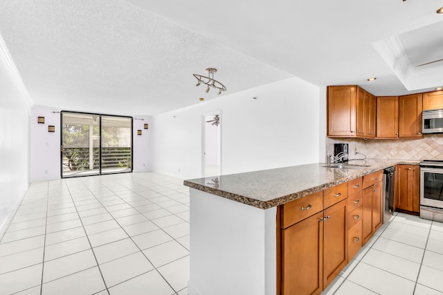 kitchen featuring stainless steel appliances, ornamental molding, sink, and kitchen peninsula