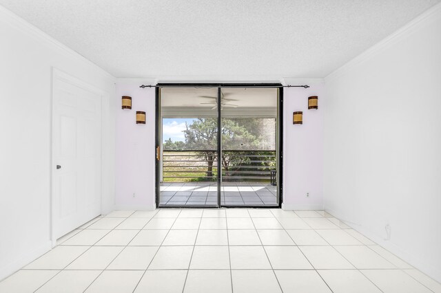 tiled spare room with crown molding and a textured ceiling