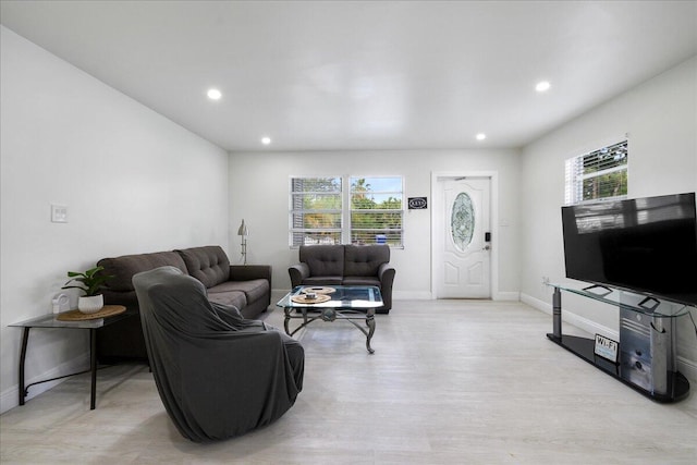 living room featuring baseboards, light wood finished floors, and recessed lighting