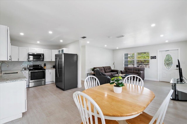 dining area featuring baseboards, light wood-type flooring, visible vents, and recessed lighting