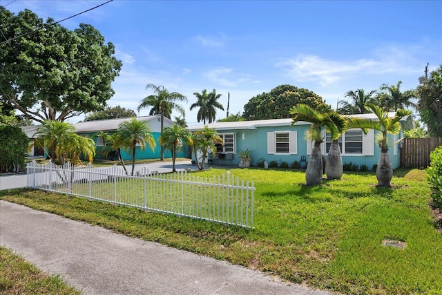 ranch-style house with stucco siding, driveway, a fenced front yard, and a front yard