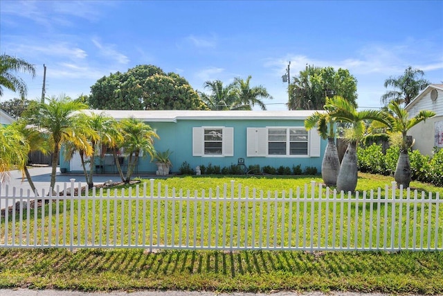 view of front facade featuring stucco siding, fence, and a front lawn