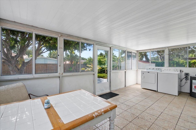 sunroom with outdoor dining space and washer and clothes dryer