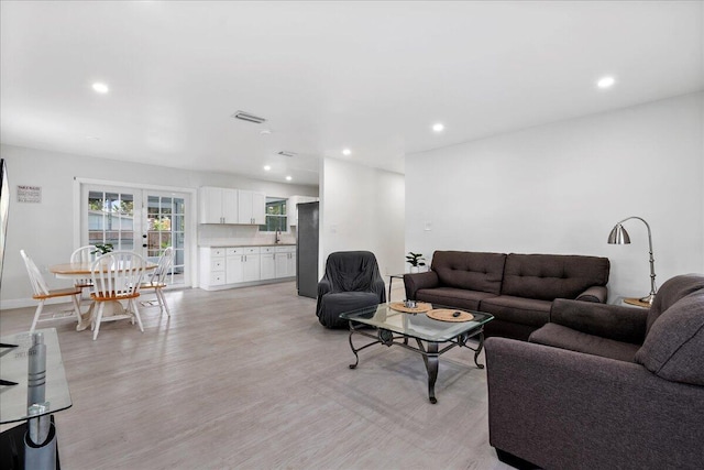 living area with baseboards, visible vents, recessed lighting, and light wood-type flooring