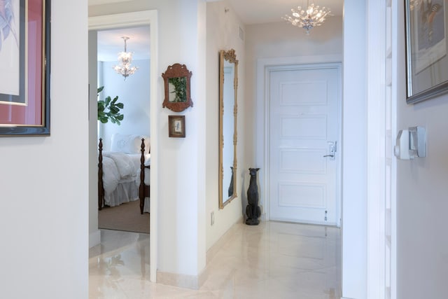 hallway featuring a notable chandelier and light tile patterned floors