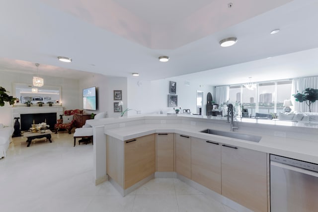 kitchen featuring light brown cabinets, light tile patterned floors, dishwasher, pendant lighting, and sink