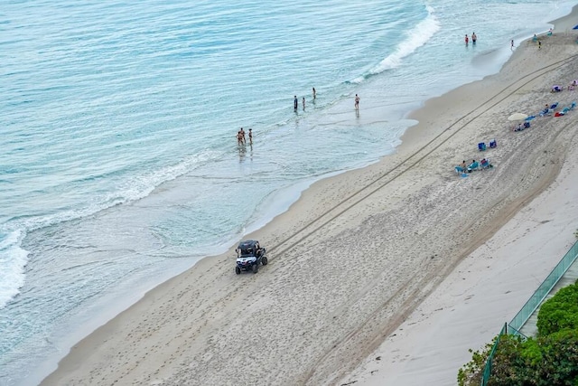 drone / aerial view featuring a beach view and a water view