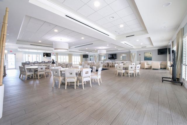 dining area featuring a raised ceiling and light wood-type flooring