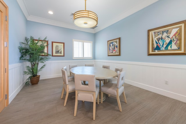 dining space featuring hardwood / wood-style floors and ornamental molding