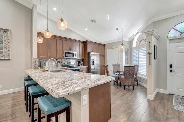 kitchen featuring hanging light fixtures, appliances with stainless steel finishes, sink, and lofted ceiling