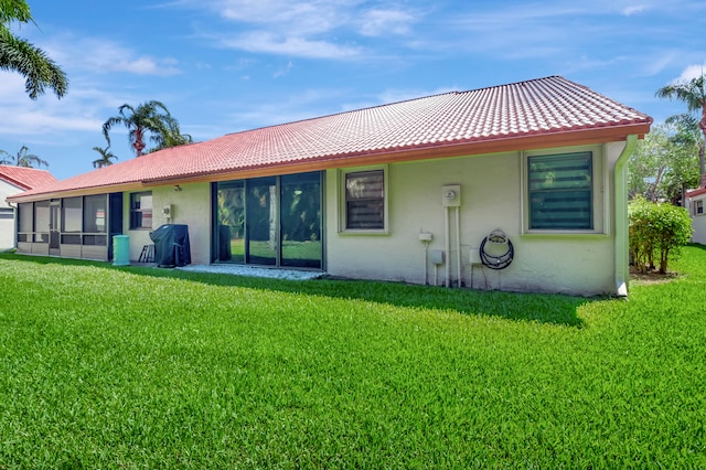 back of house with a sunroom and a yard