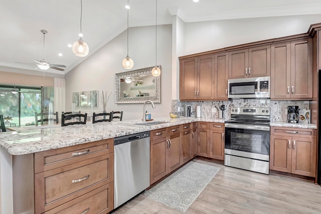 kitchen featuring hanging light fixtures, light hardwood / wood-style flooring, appliances with stainless steel finishes, backsplash, and ceiling fan