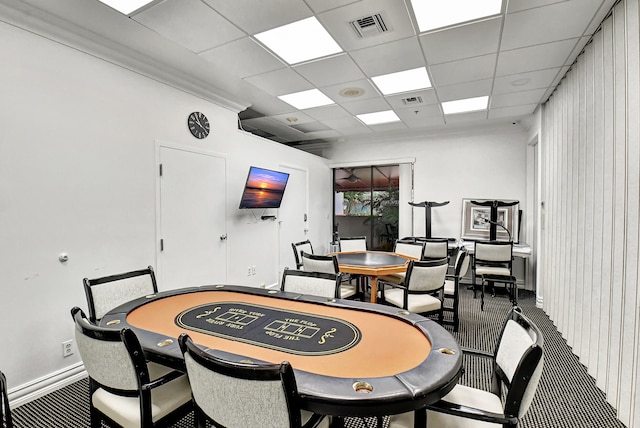 carpeted dining area with a drop ceiling