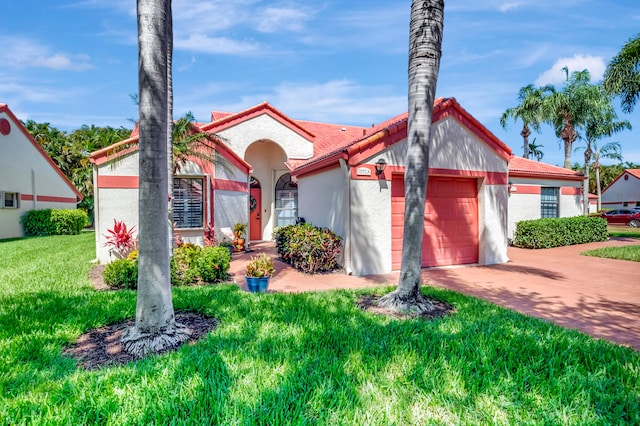 mediterranean / spanish-style home with a garage and a front lawn