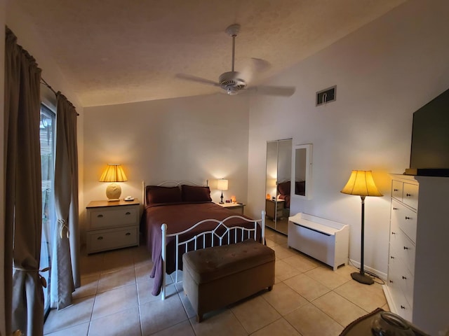 bedroom featuring ceiling fan, vaulted ceiling, and light tile floors