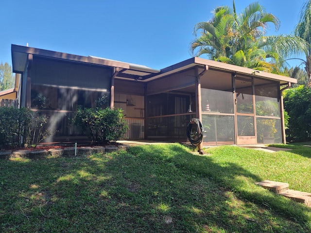 back of house with a sunroom and a yard