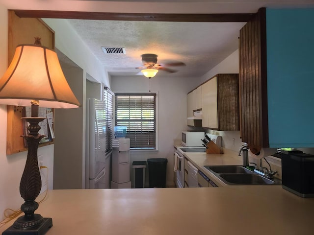 kitchen with ceiling fan, white appliances, a textured ceiling, sink, and white cabinetry