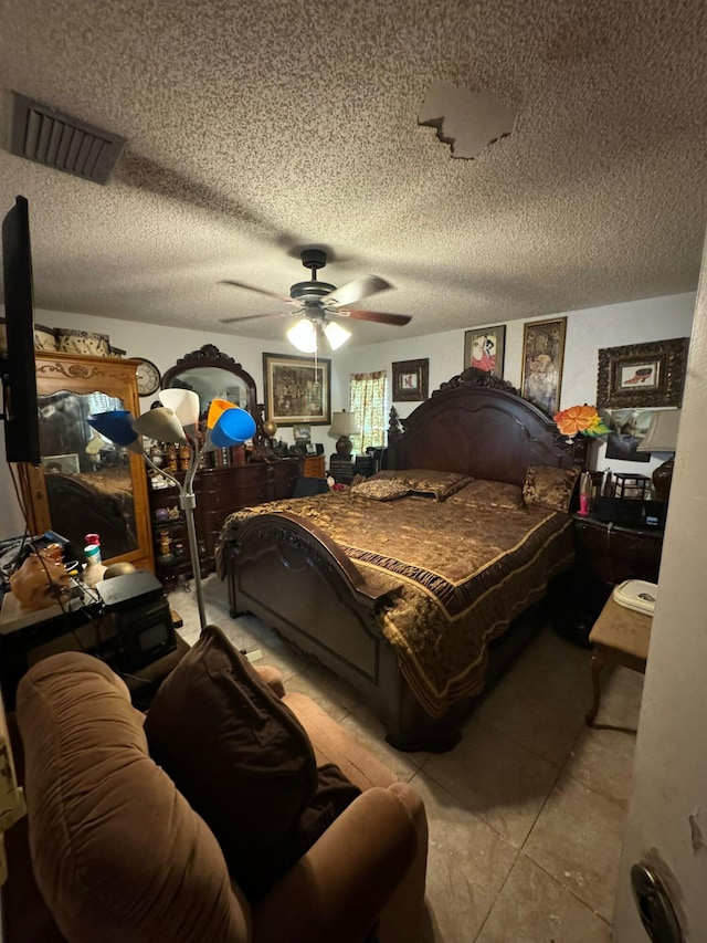 bedroom featuring ceiling fan, a textured ceiling, and light tile patterned floors