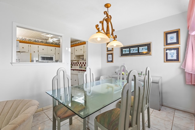 dining space featuring light tile flooring and a chandelier