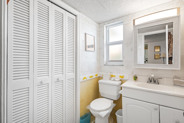 bathroom featuring toilet, vanity, and a textured ceiling