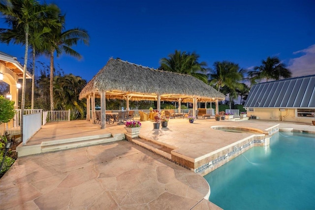 pool at twilight with a gazebo and a patio