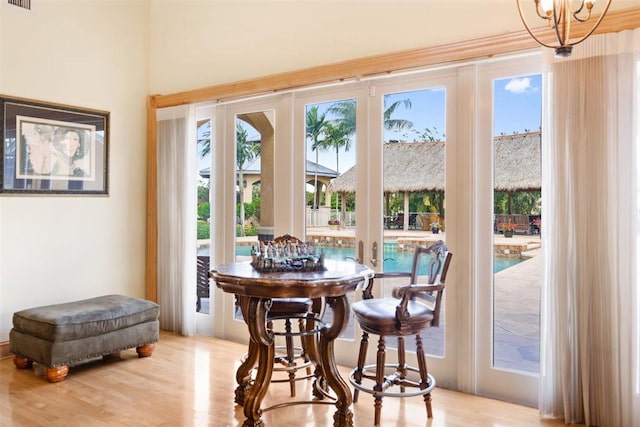 dining area with a chandelier, light hardwood / wood-style floors, and french doors