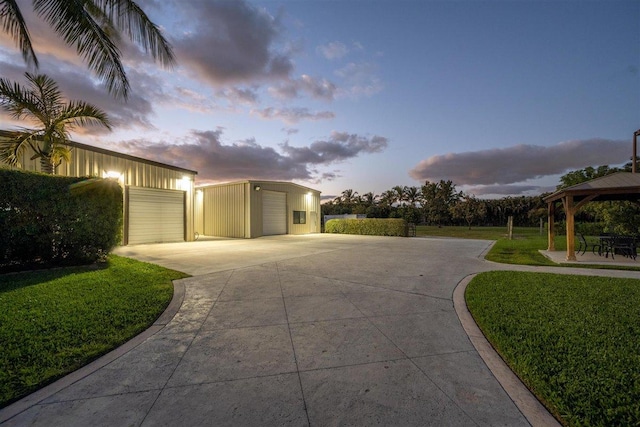 exterior space featuring a lawn, a gazebo, and a garage