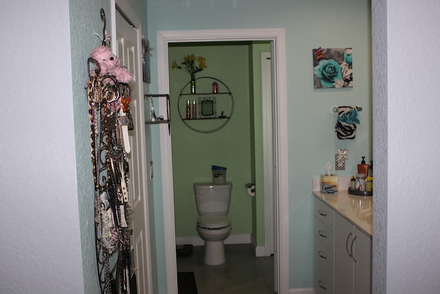 bathroom with vanity, tile floors, and toilet