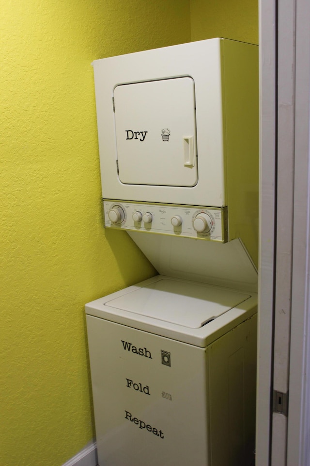 clothes washing area featuring stacked washer and dryer