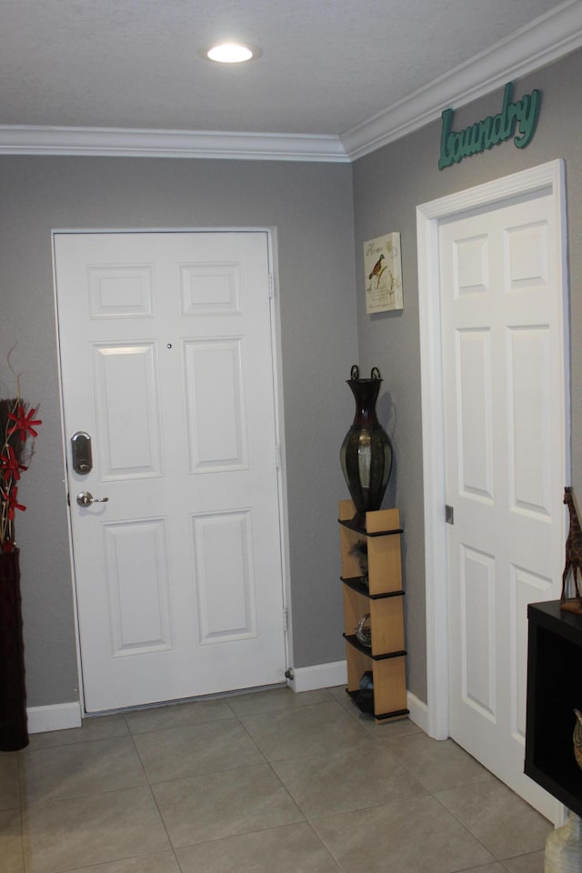 entrance foyer featuring light tile flooring and ornamental molding