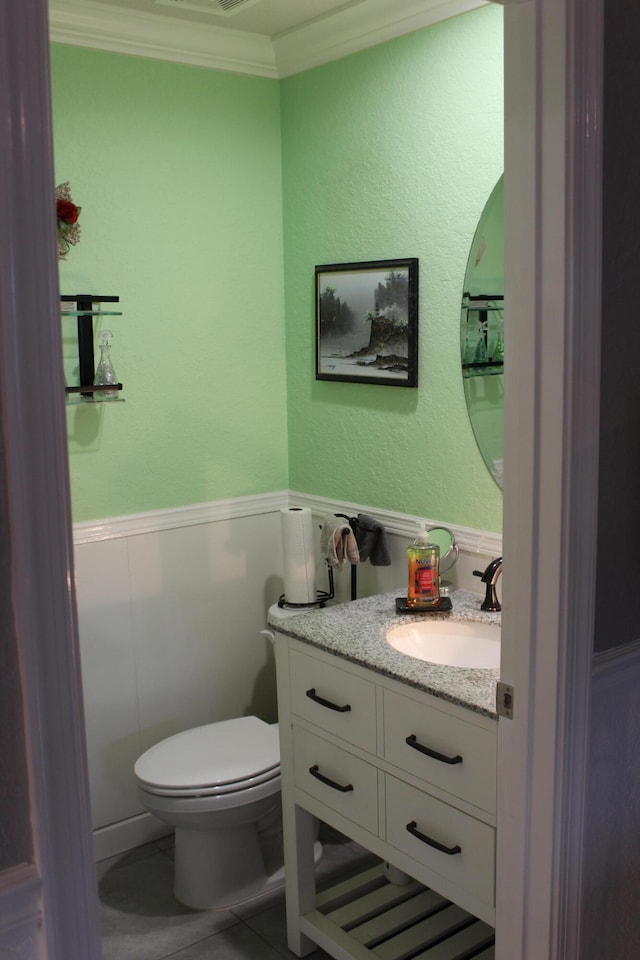 bathroom featuring toilet, ornamental molding, and vanity