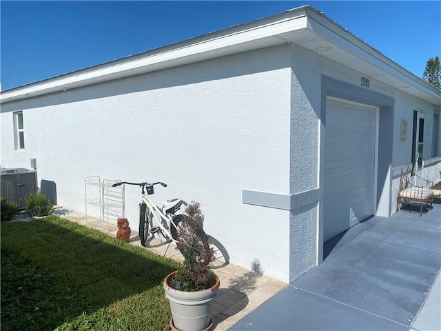 view of home's exterior featuring central AC, a garage, and a yard