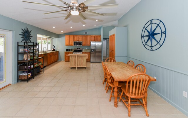 dining room with lofted ceiling, sink, ceiling fan, and light tile patterned flooring