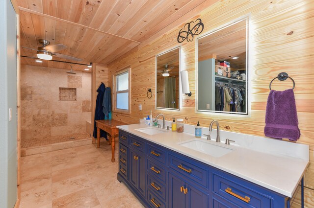 bathroom featuring wood ceiling, ceiling fan, vanity, and a tile shower