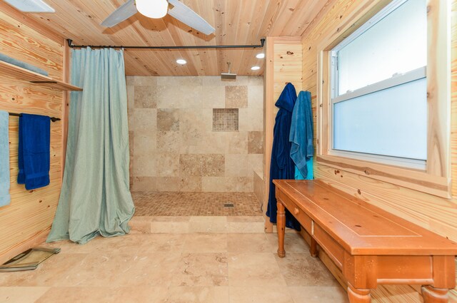 bathroom with tiled shower, wooden ceiling, and ceiling fan